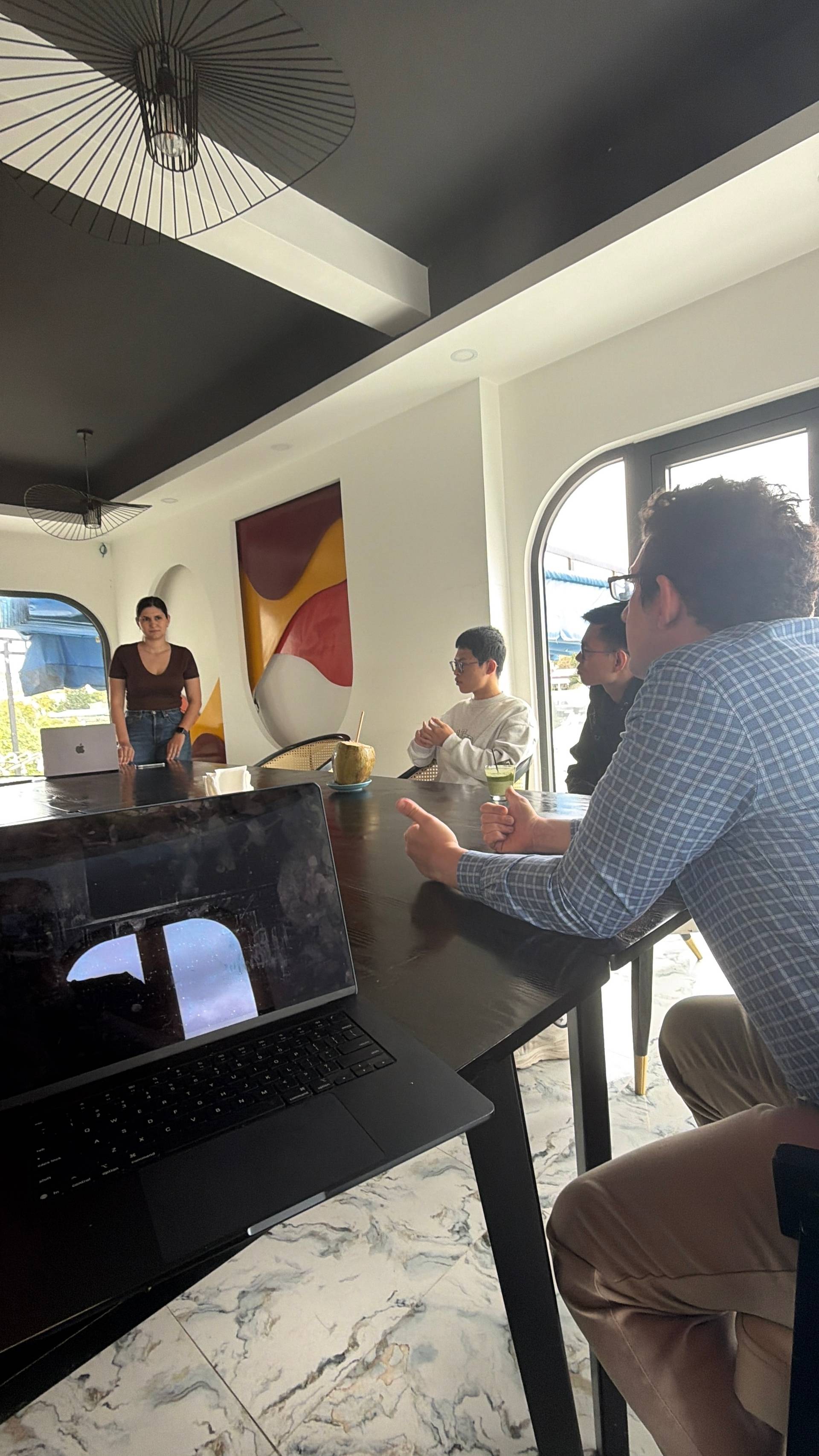 A participant enjoys a refreshment during a networking event in a modern Đà Lạt venue, capturing a moment of casual engagement at a professional gathering.