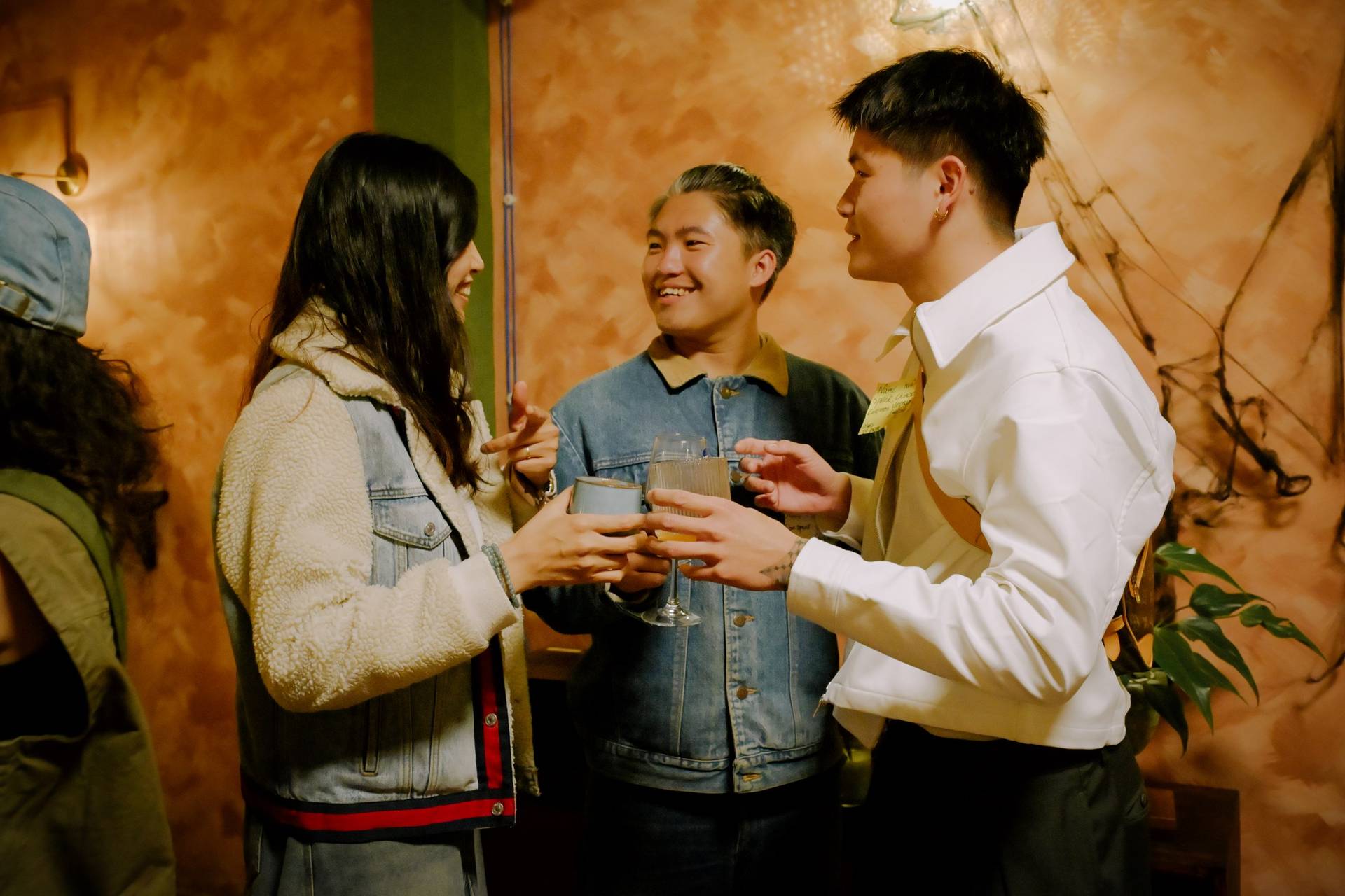 A group of friends toasting with drinks in a cozy indoor setting in Đà Lạt, Vietnam, exuding a warm and festive atmosphere.