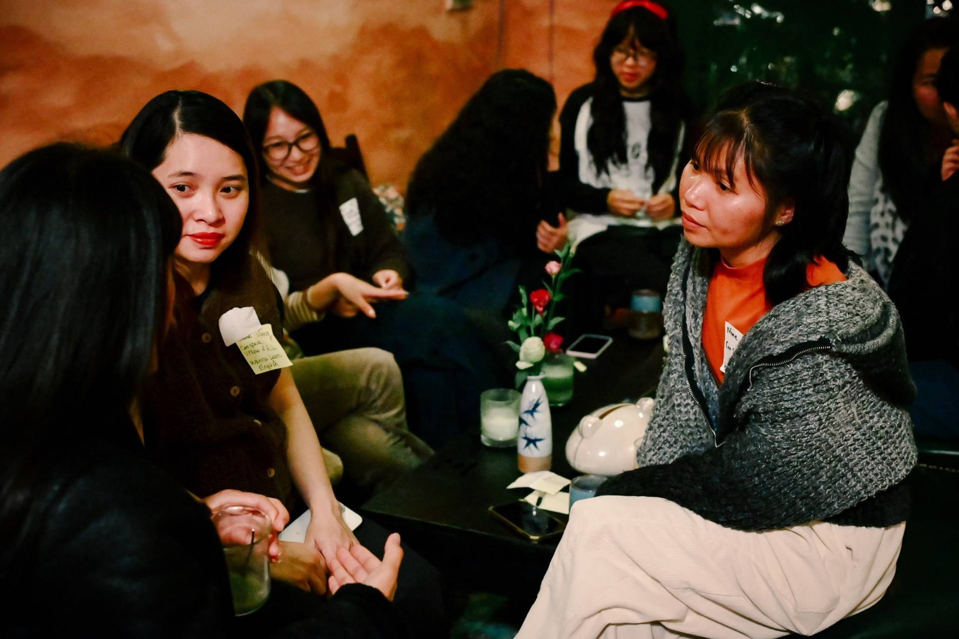 A group of friends gathered in a cozy café in Đà Lạt, Vietnam, engaging in lively conversation and enjoying drinks together.