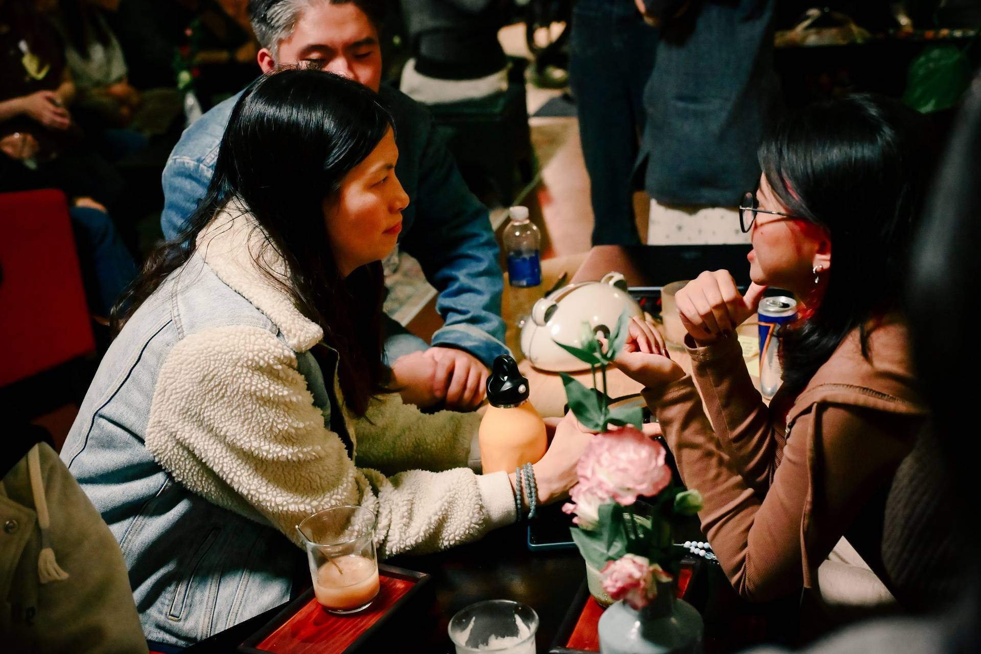 Two friends share a quiet moment over drinks in a cozy café setting in Đà Lạt, Vietnam.