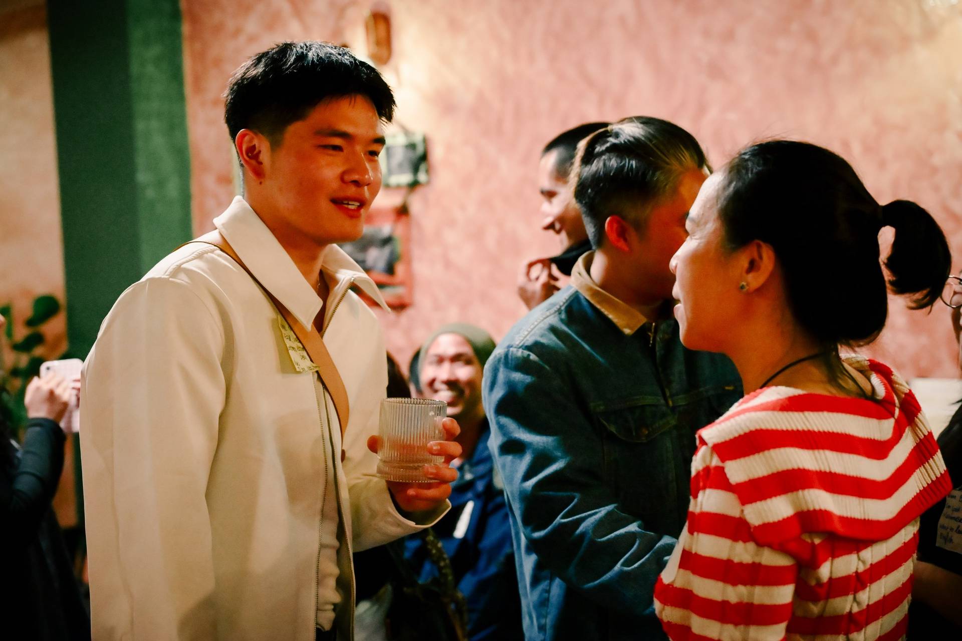 A lively gathering in Đà Lạt, Vietnam, where friends enjoy each other's company and share drinks in a cozy indoor setting.