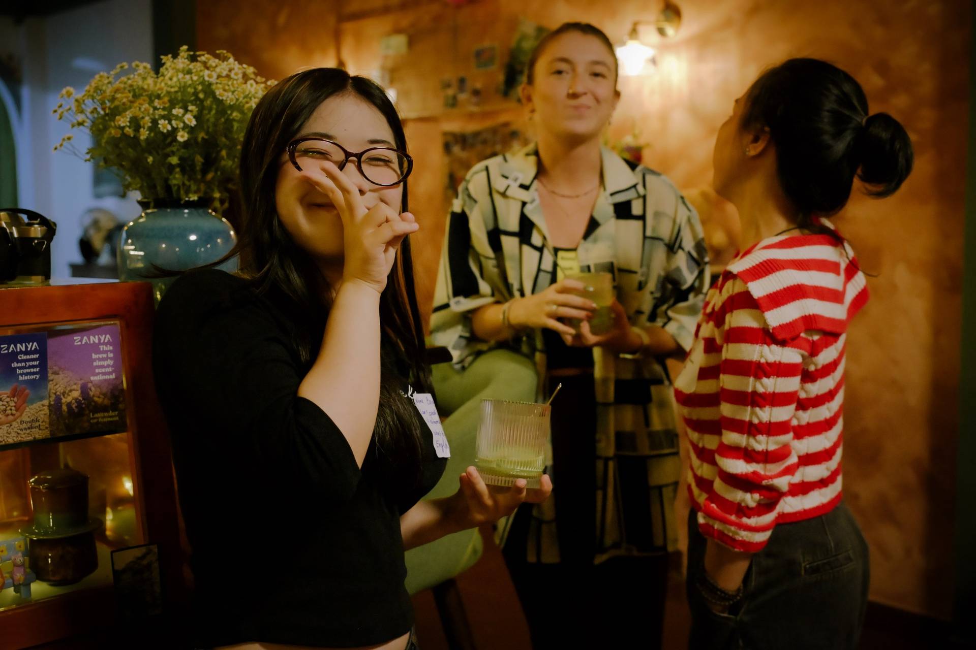 A group of friends share a joyful moment in a cozy café setting in Đà Lạt, Vietnam, enjoying drinks and laughter together.