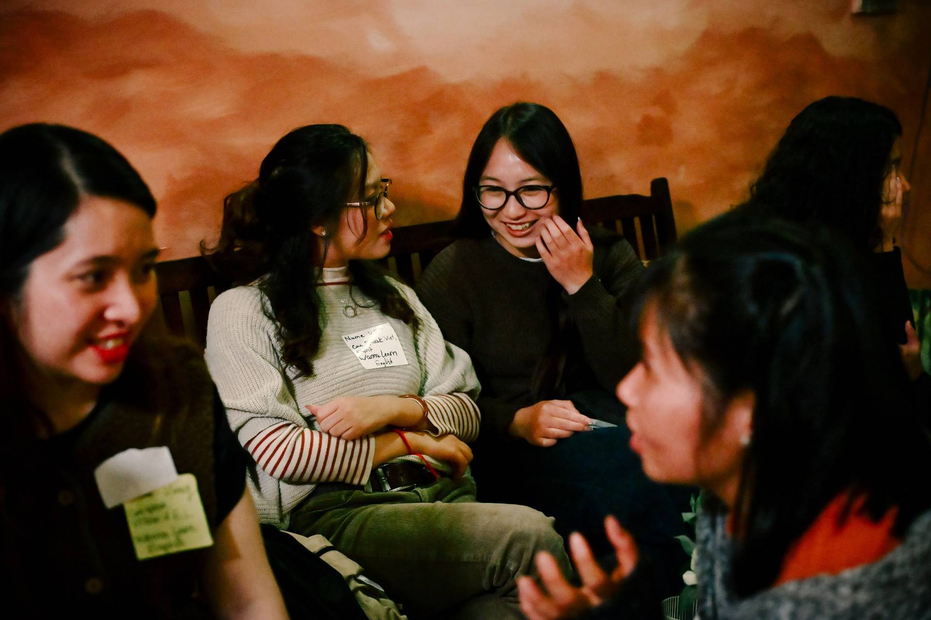 A group of friends share laughter over a board game in a cozy setting within Đà Lạt, Vietnam.