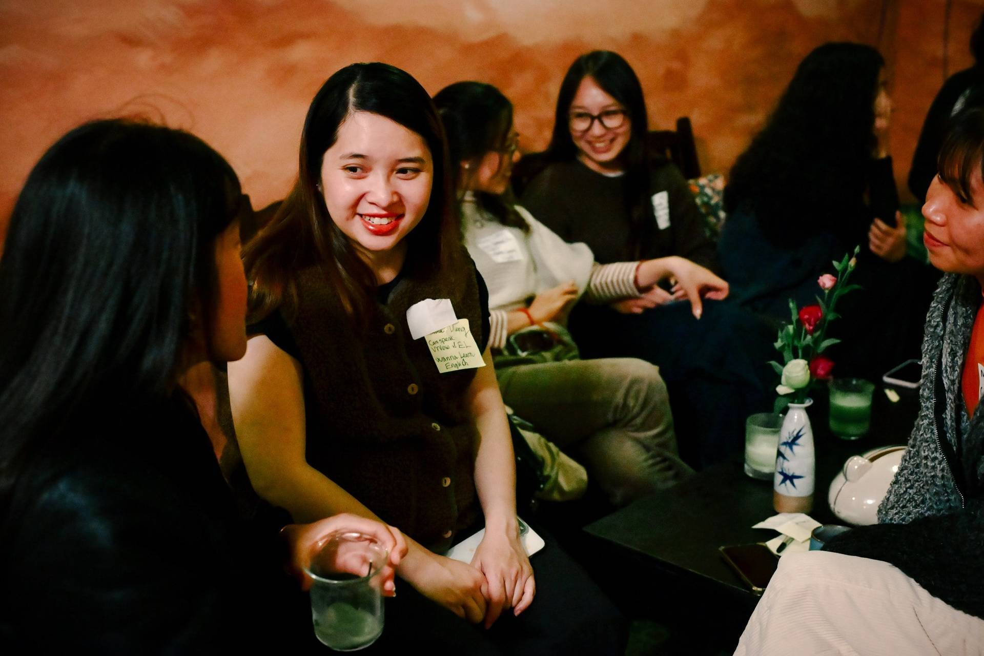 A group of friends gather in a cozy café in Đà Lạt, Vietnam, sharing laughter and conversation over drinks.