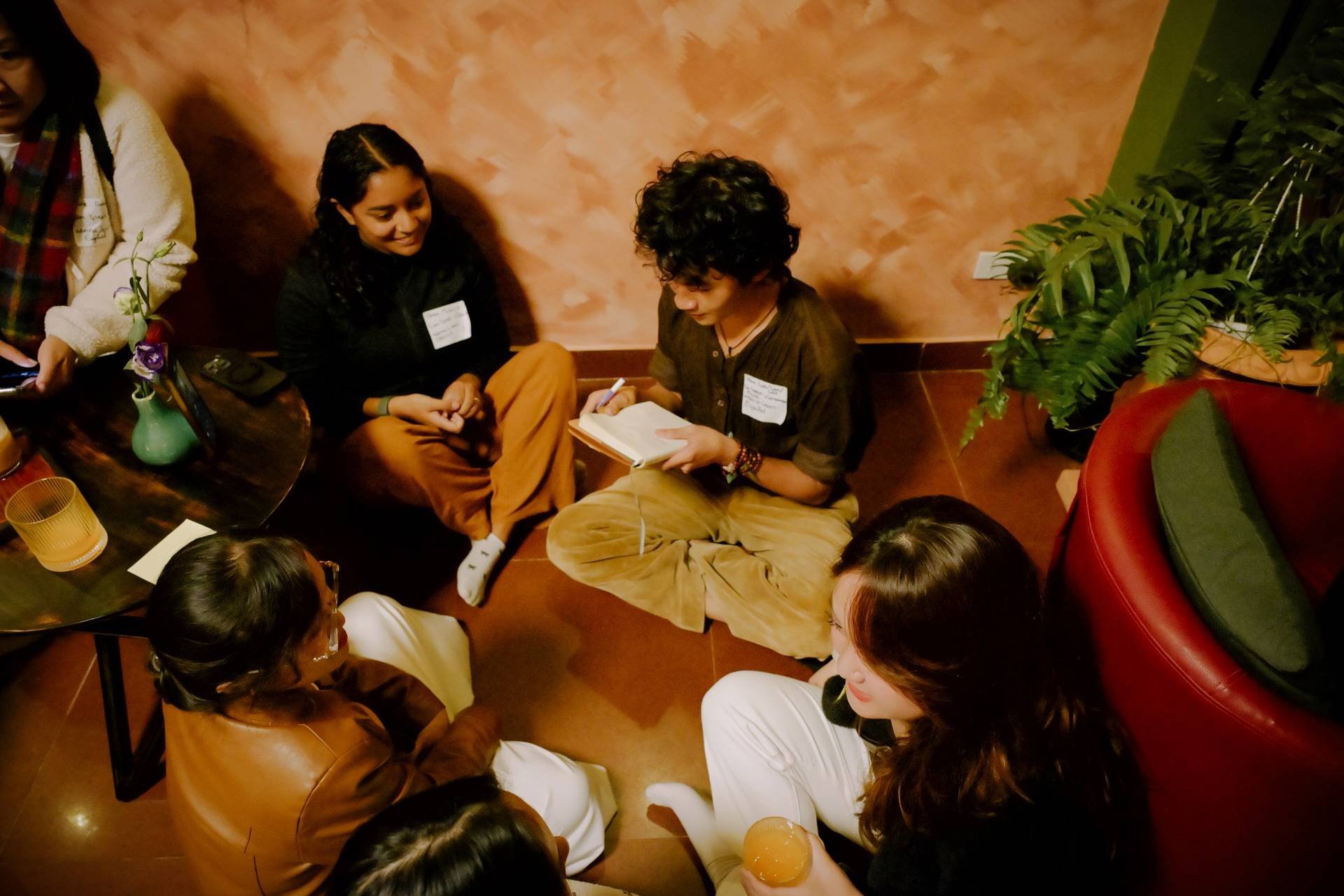 A group of friends gathered in a cozy café in Đà Lạt, Vietnam, engaging in lively conversation and enjoying drinks together.