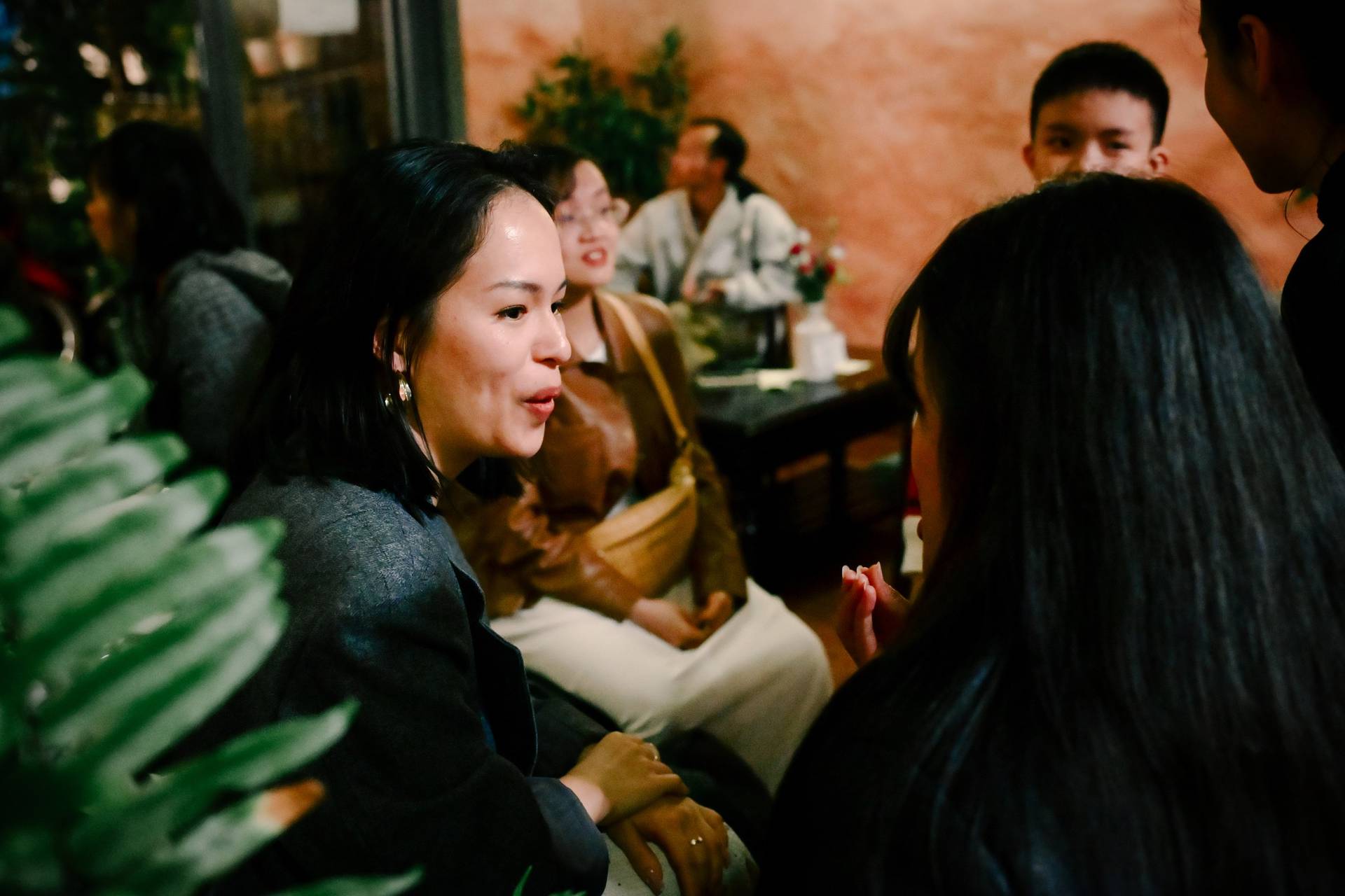 A group of friends enjoys a cozy evening in Đà Lạt, Vietnam, sharing laughter and conversation around a table adorned with flowers.