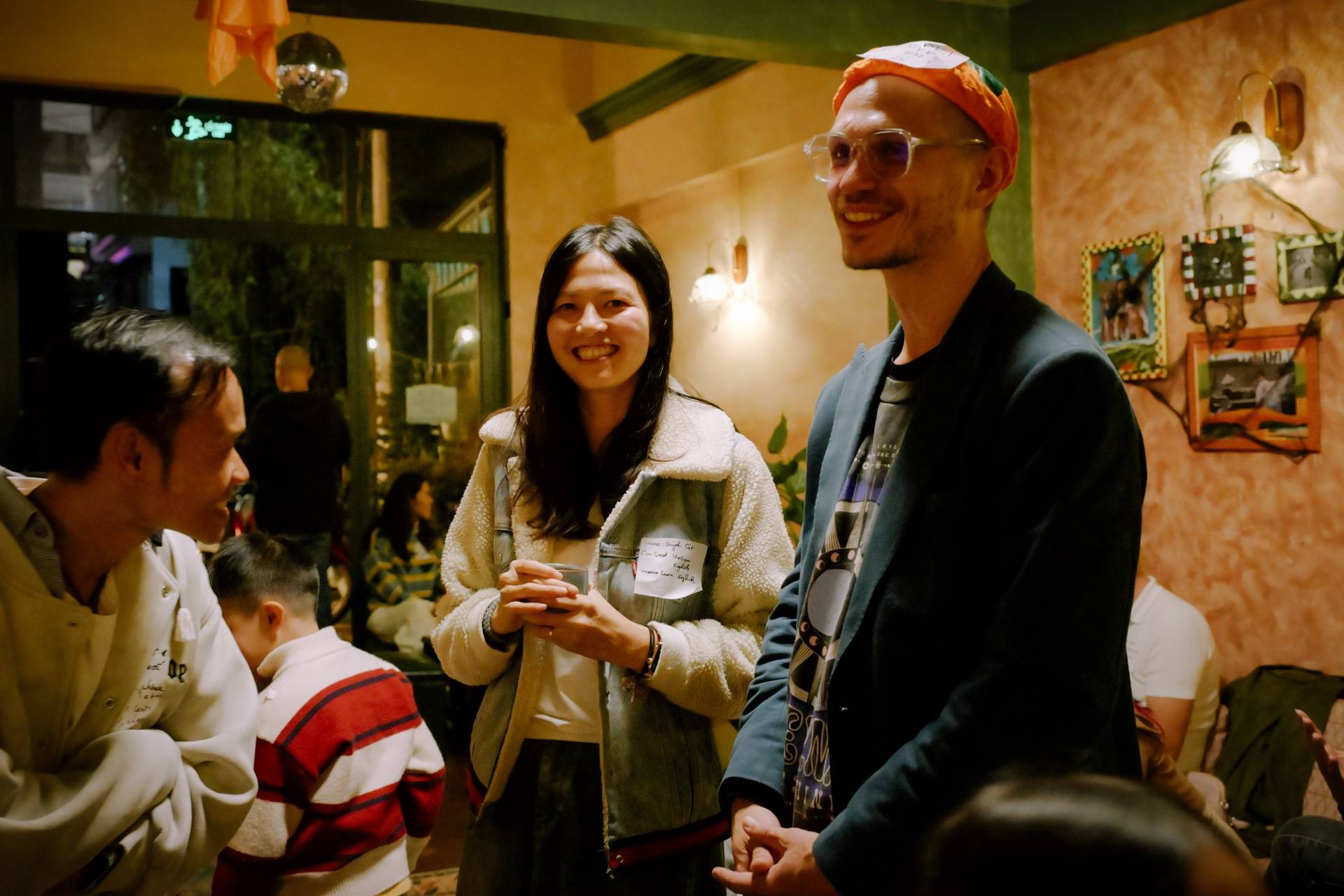 A lively gathering in a cozy café in Đà Lạt, Vietnam, where friends enjoy drinks and conversation under warm lighting.