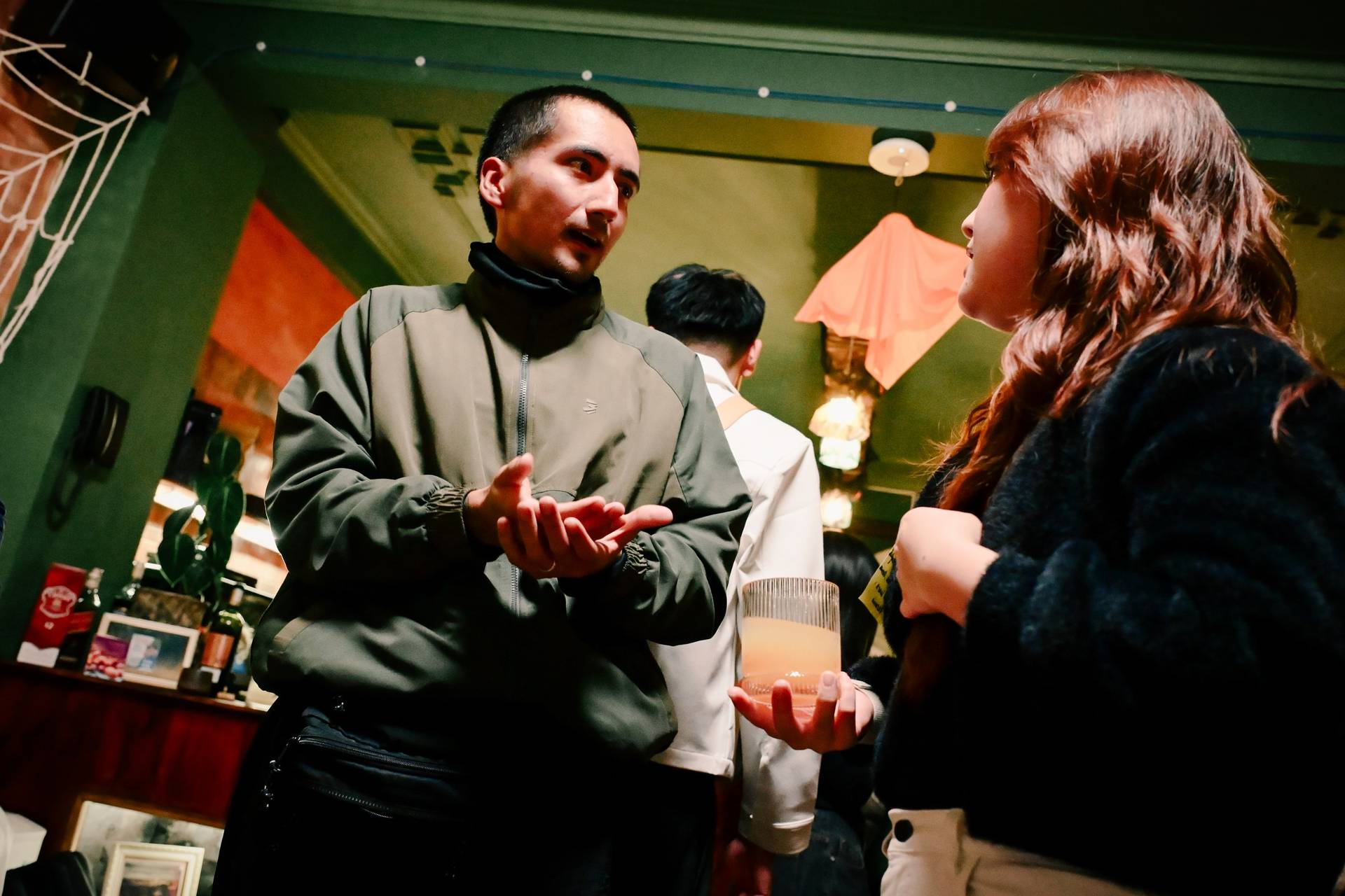 A lively gathering in Đà Lạt, Vietnam, where friends engage in conversation over drinks and festive decorations add a warm ambiance.