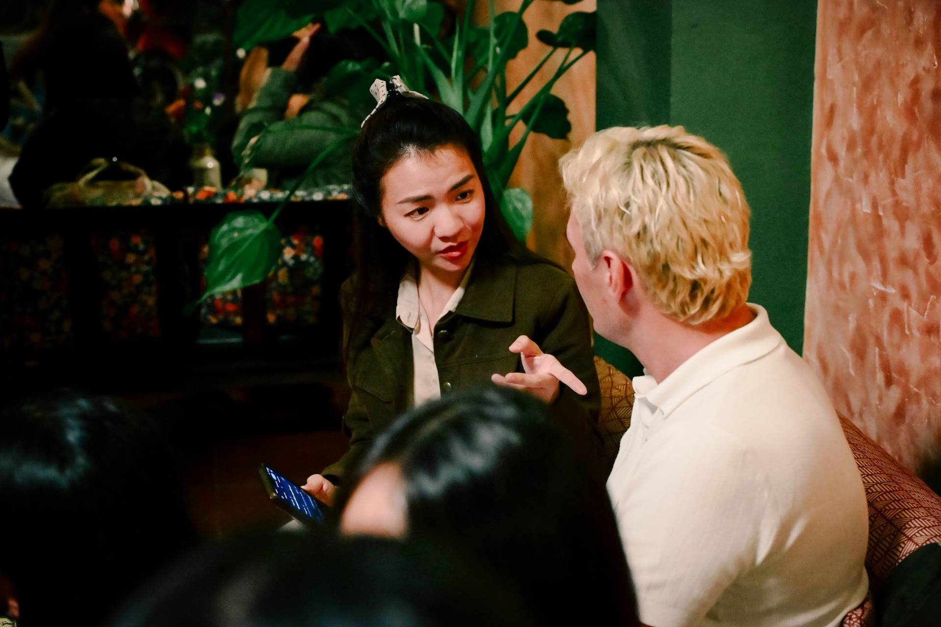 A group of friends engaged in conversation during a social gathering in Đà Lạt's vibrant nightlife scene.