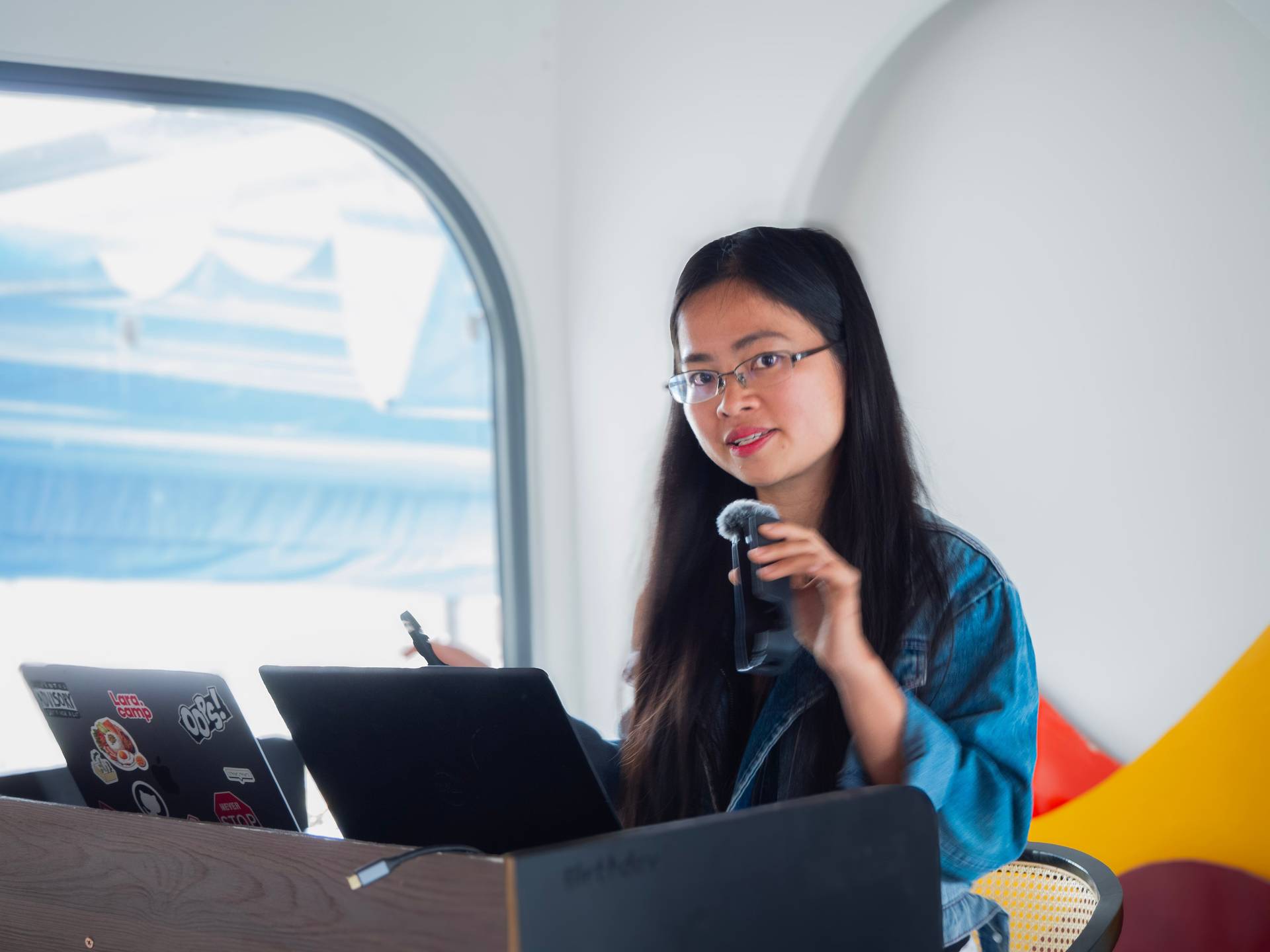 An engaged speaker addresses the audience during a professional event or conference in Đà Lạt, with laptops and modern venue elements visible. The dynamic presentation captures the energy of knowledge-sharing and community engagement.