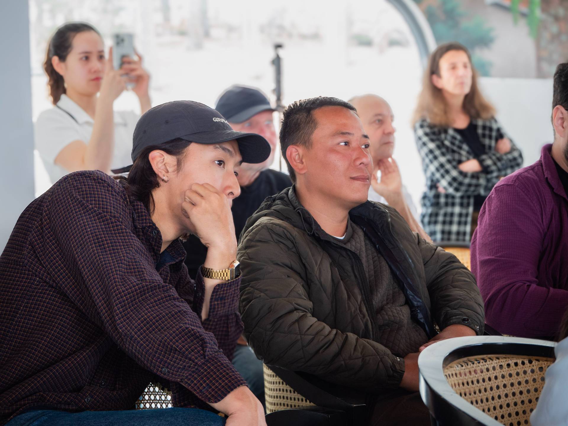 Mixed group of attendees seated together at a community event, displaying concentration and engagement during a presentation or discussion.