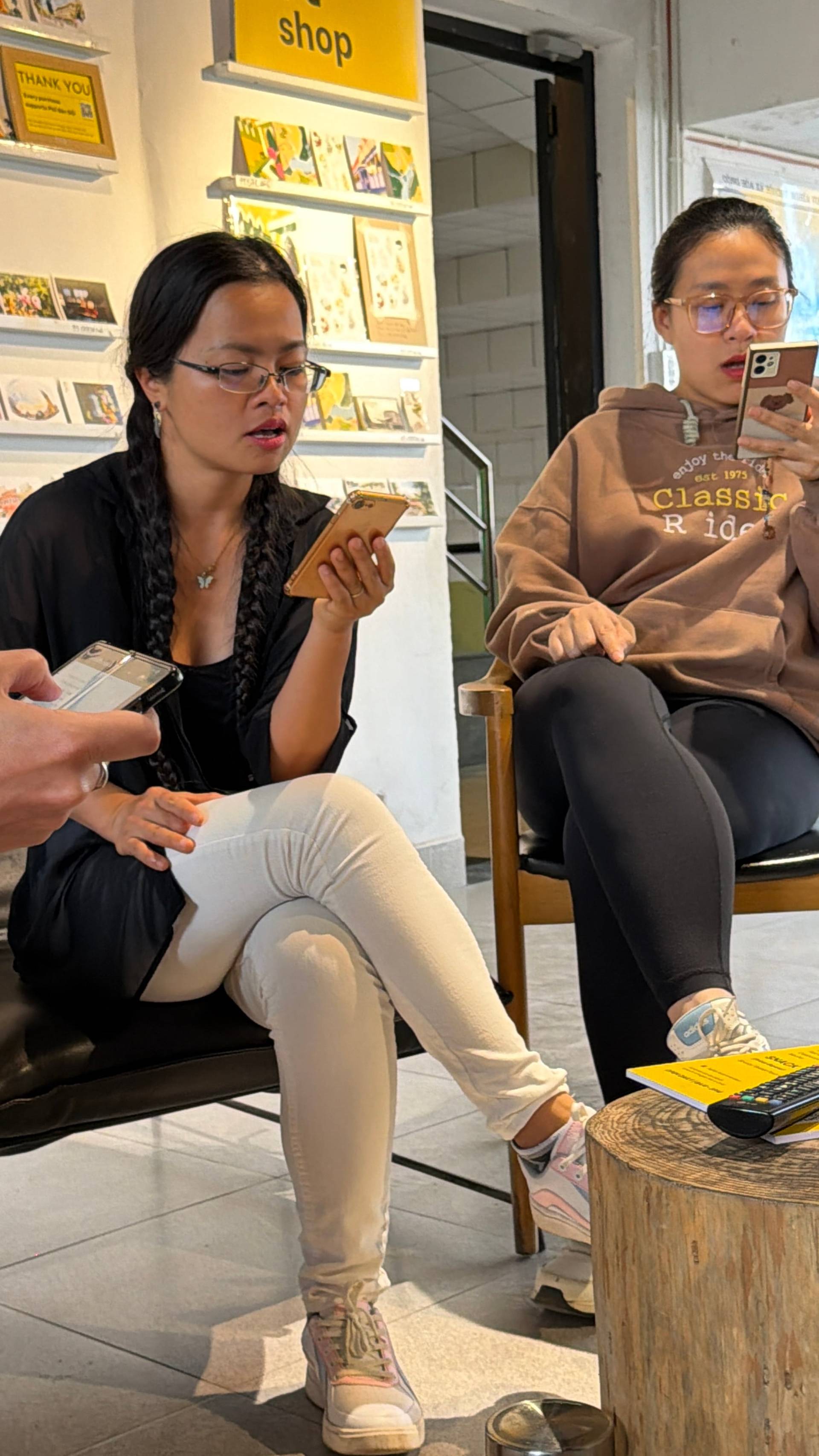 A cozy gathering in a creative studio space in Đà Lạt, surrounded by local postcards and curated artwork, perfect for art enthusiasts.