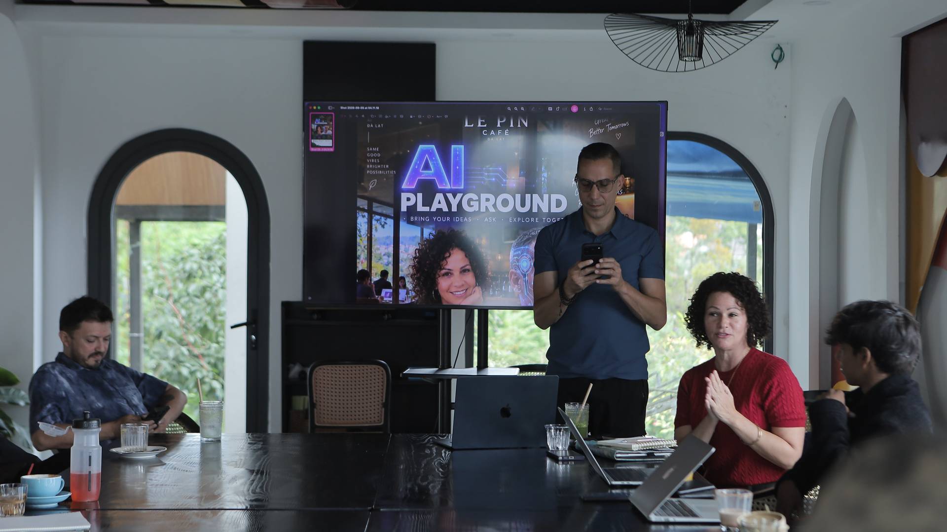 A group of people gathered in a modern café setting in Đà Lạt, Vietnam, participating in an AI-themed workshop or presentation.