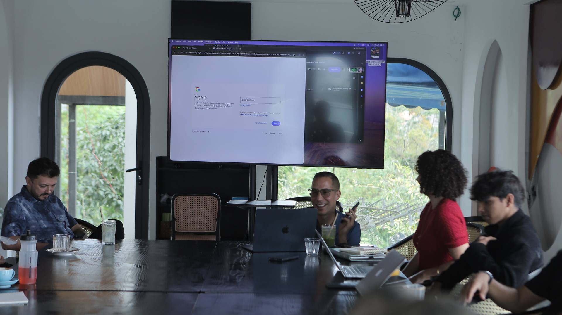 A group of people gathered around a large screen in a modern Vietnamese setting, engaging with digital content and enjoying a casual atmosphere.