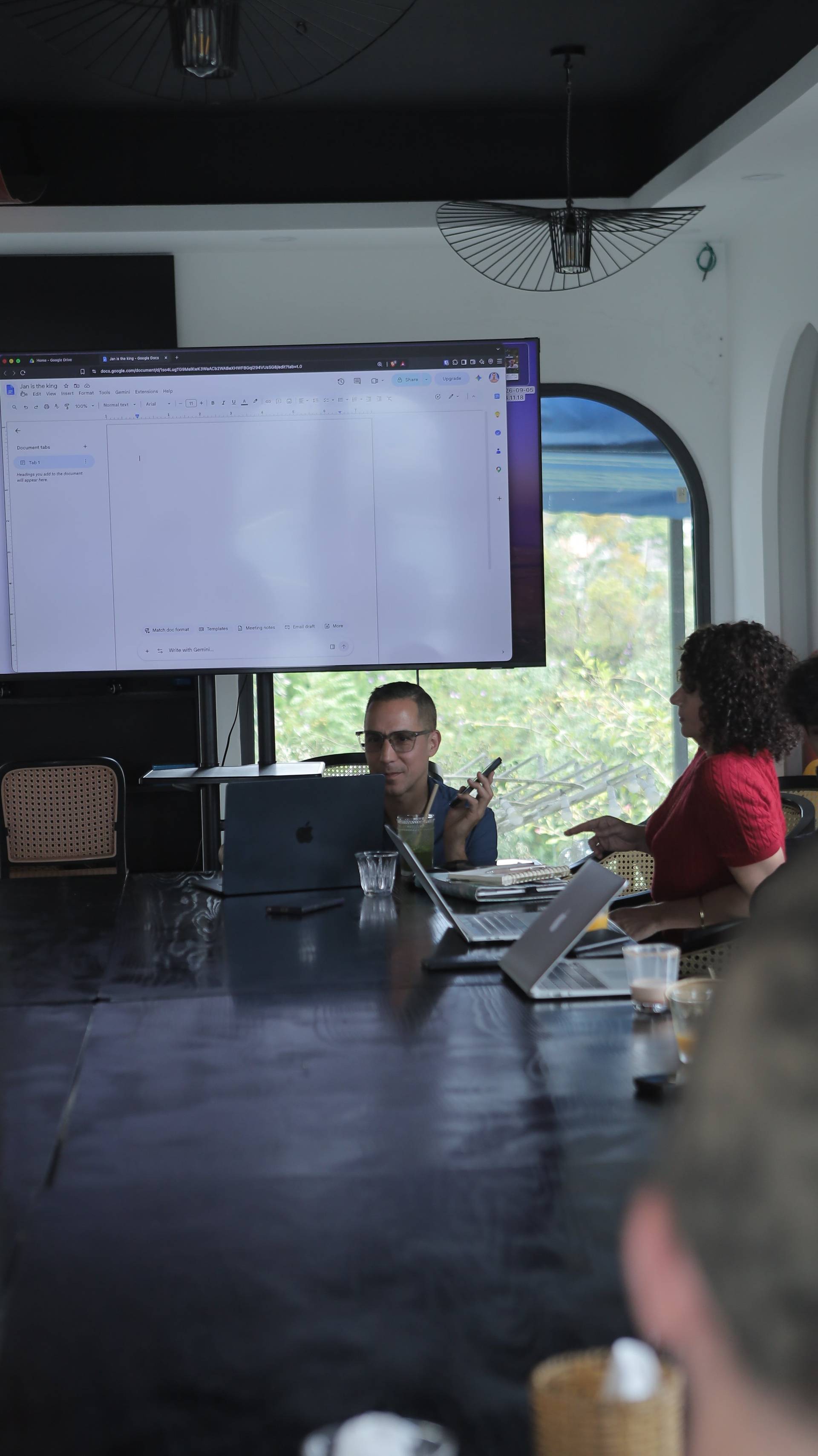 A group of professionals collaborates in a modern conference room with large windows overlooking lush greenery in Đà Lạt, Vietnam.