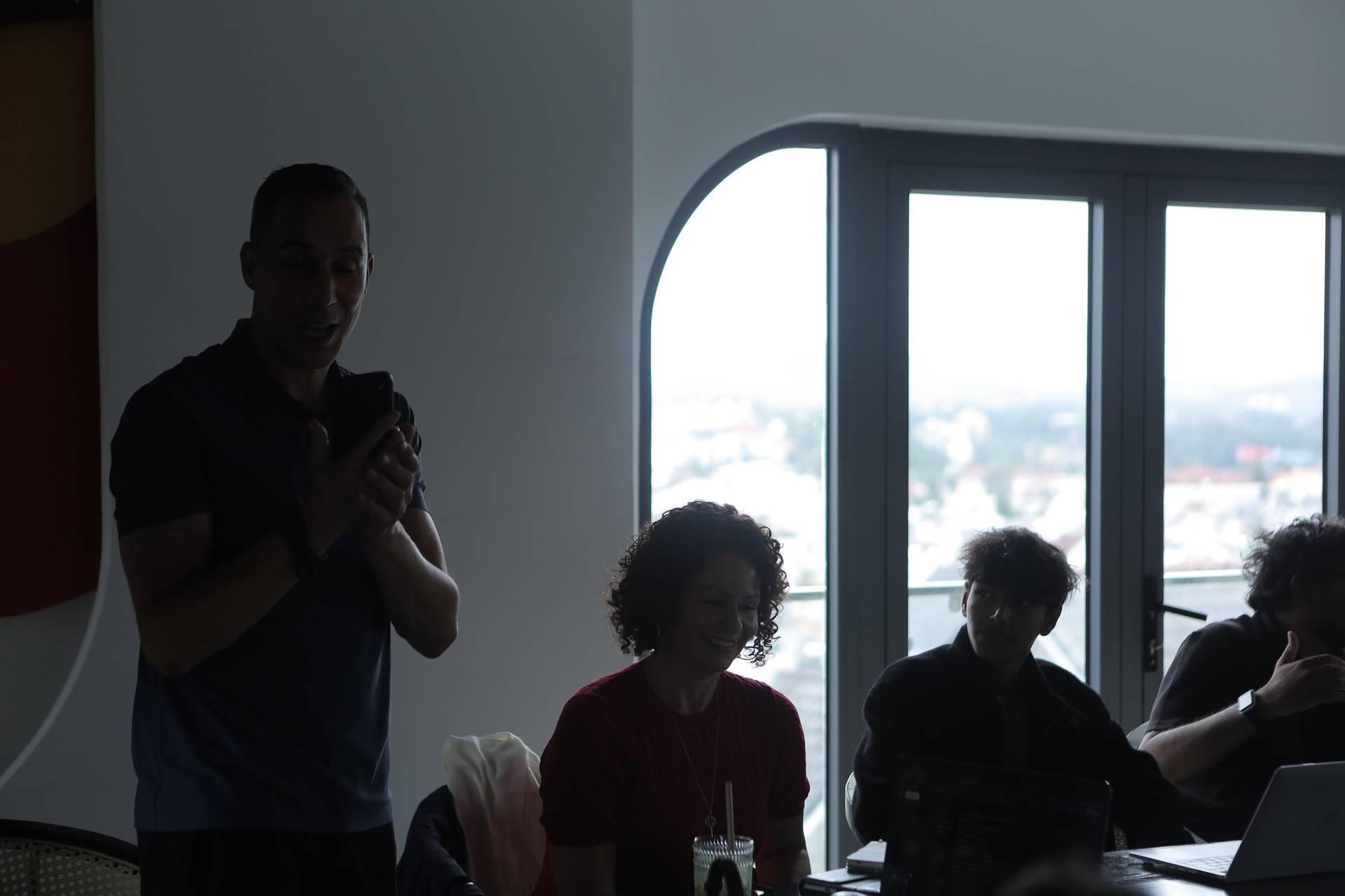 A group of people enjoying a casual gathering in Đà Lạt, Vietnam, with one individual holding up a phone as if taking a photo or showing something to others.