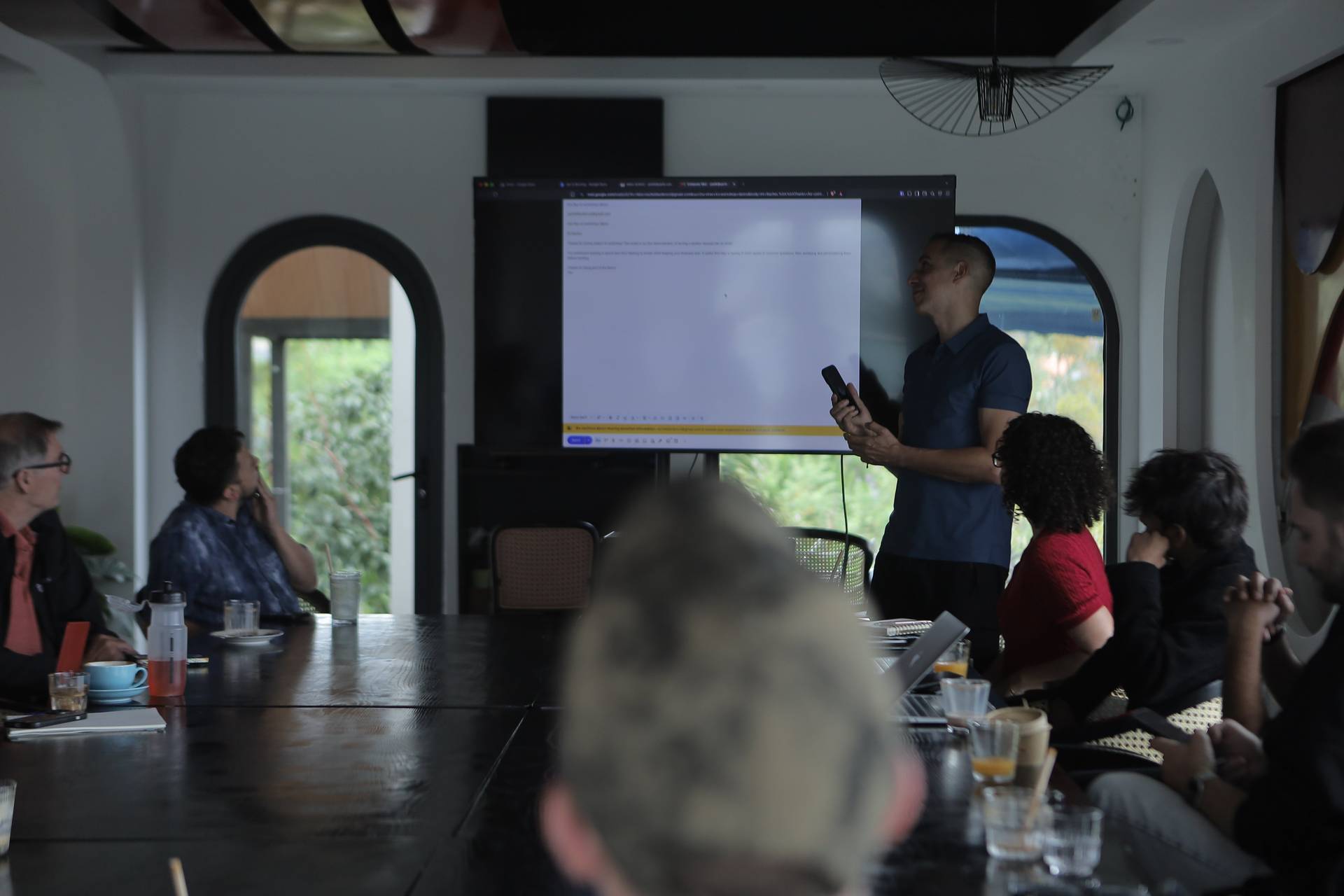 A professional meeting in a modern conference room in Đà Lạt, Vietnam, with participants engaged in discussion and a presenter using a large screen.