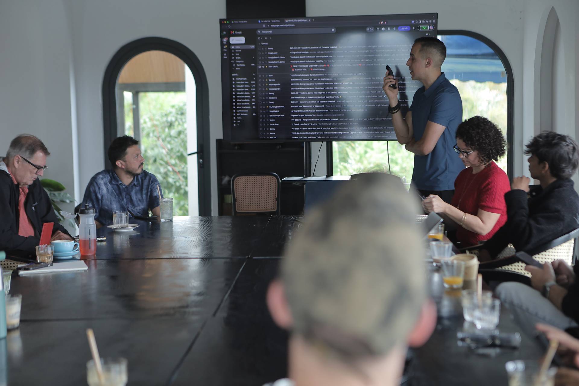 A professional meeting is taking place in a modern conference room with large windows overlooking greenery in Đà Lạt, Vietnam.