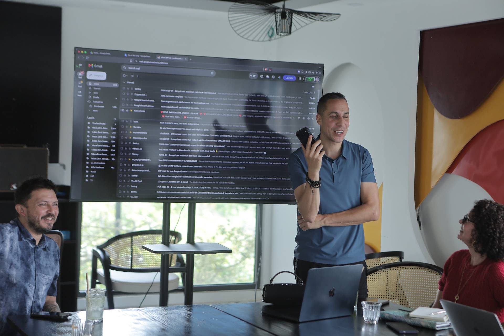 A professional meeting in Đà Lạt, Vietnam, with participants engaged in a discussion around a large screen displaying email content.