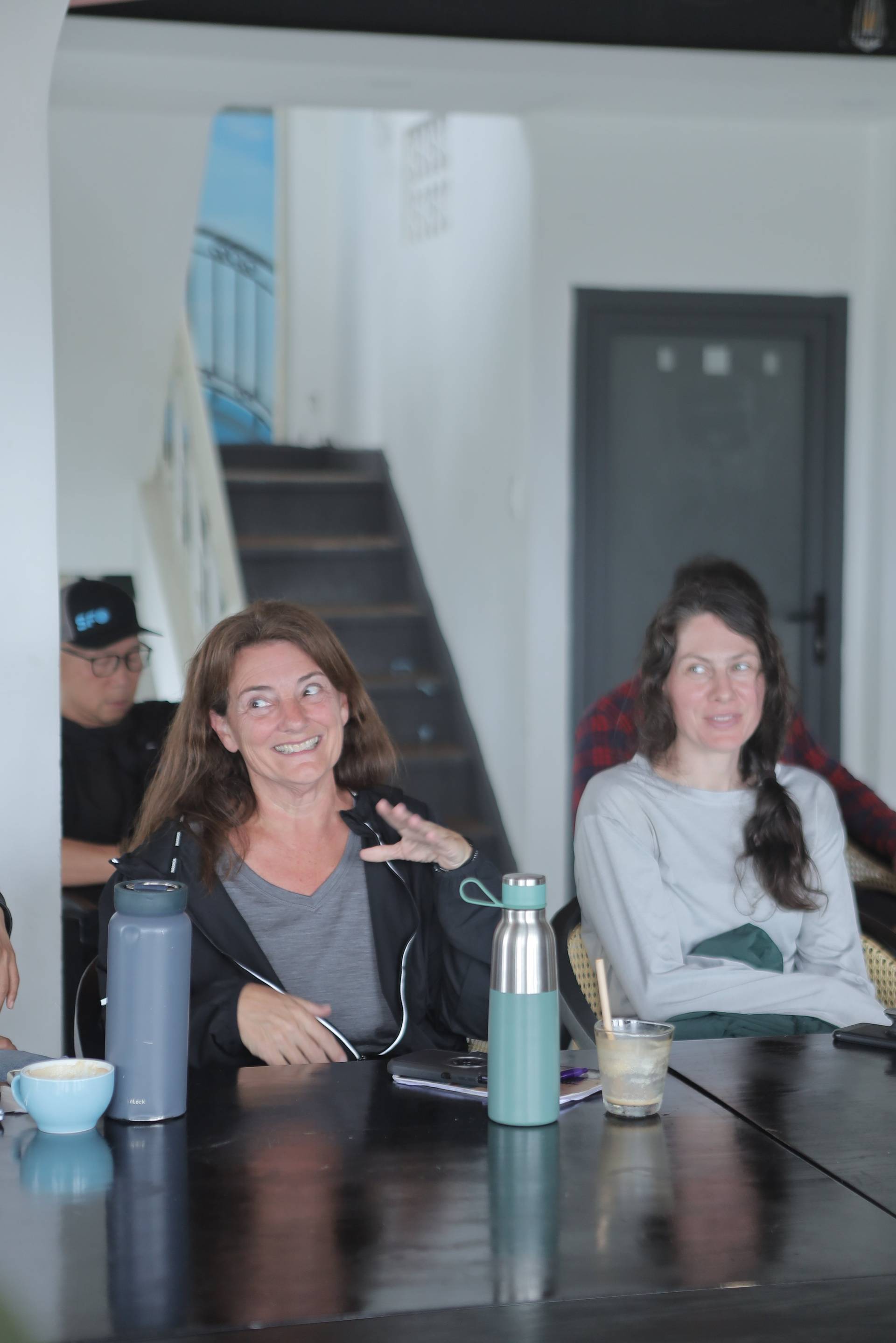 A group of friends enjoys a casual gathering in Đà Lạt, Vietnam, with laughter and conversation over drinks and snacks.