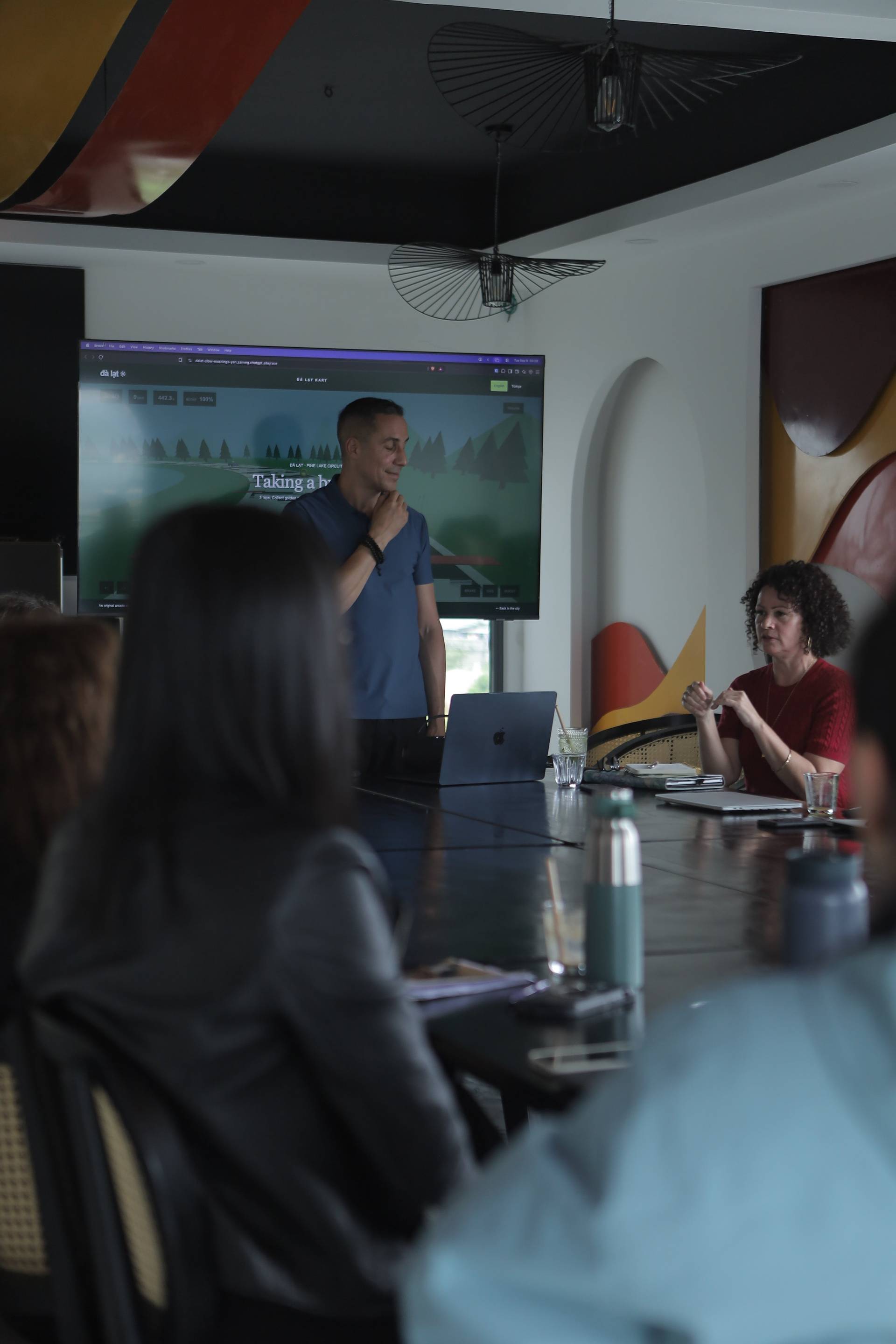 A professional meeting in Đà Lạt, Vietnam, featuring a presentation with scenic imagery displayed on a large screen.