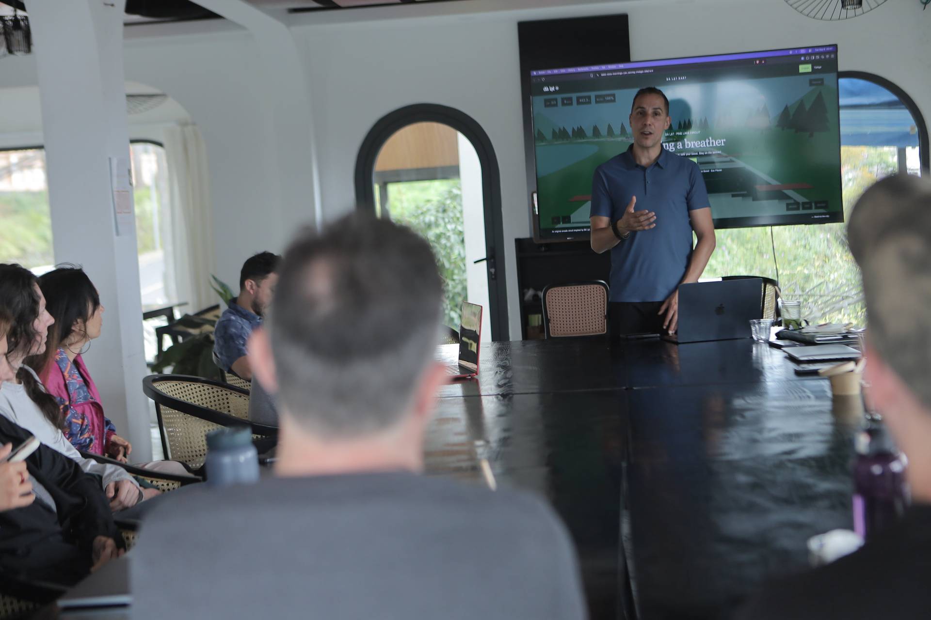 A professional presentation in a modern conference room with attendees focused on a speaker discussing a scenic landscape theme.
