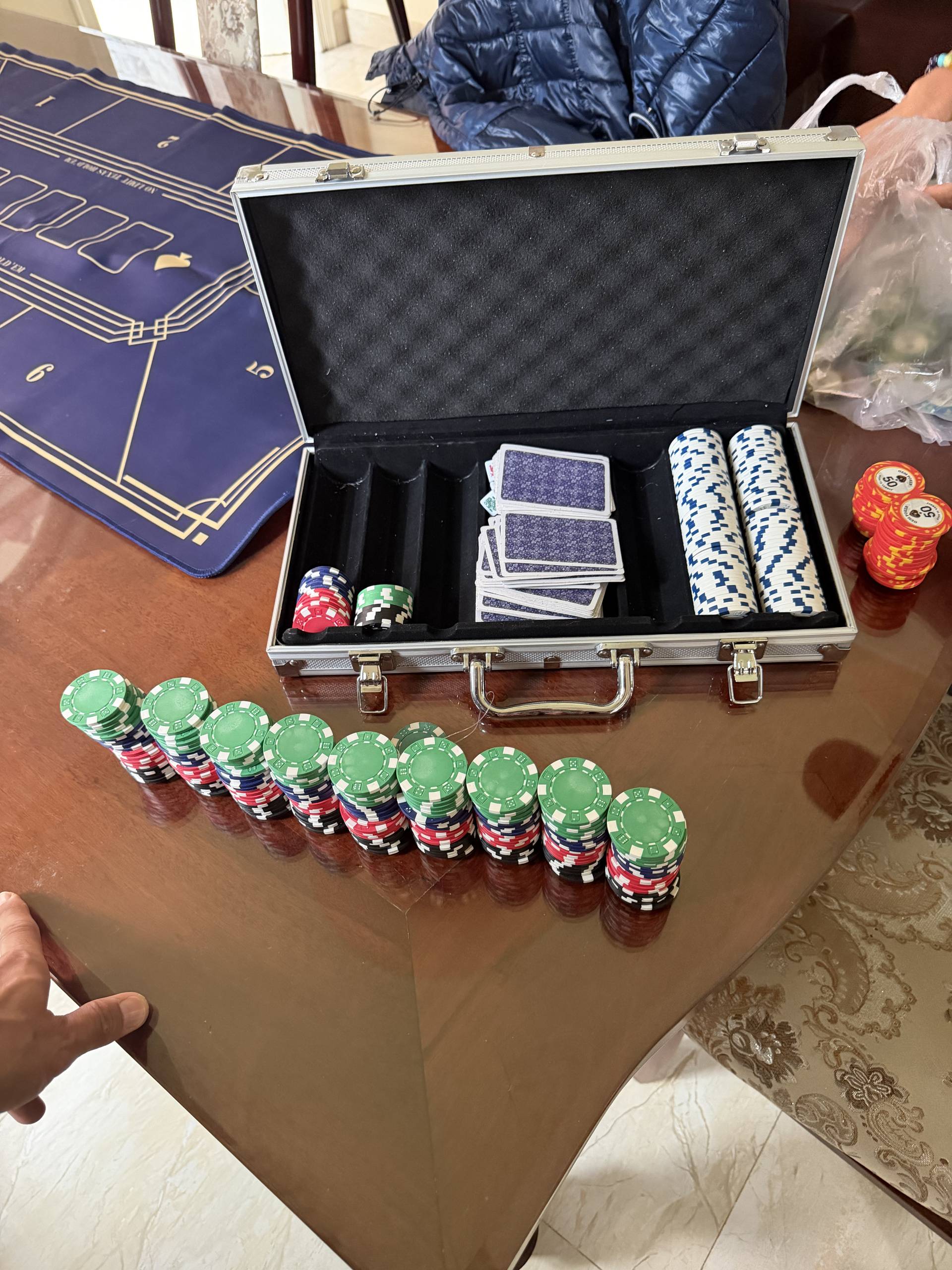 Professional poker set in an aluminum carrying case with organized chips and cards displayed on a gaming mat during an event showcase in Đà Lạt.