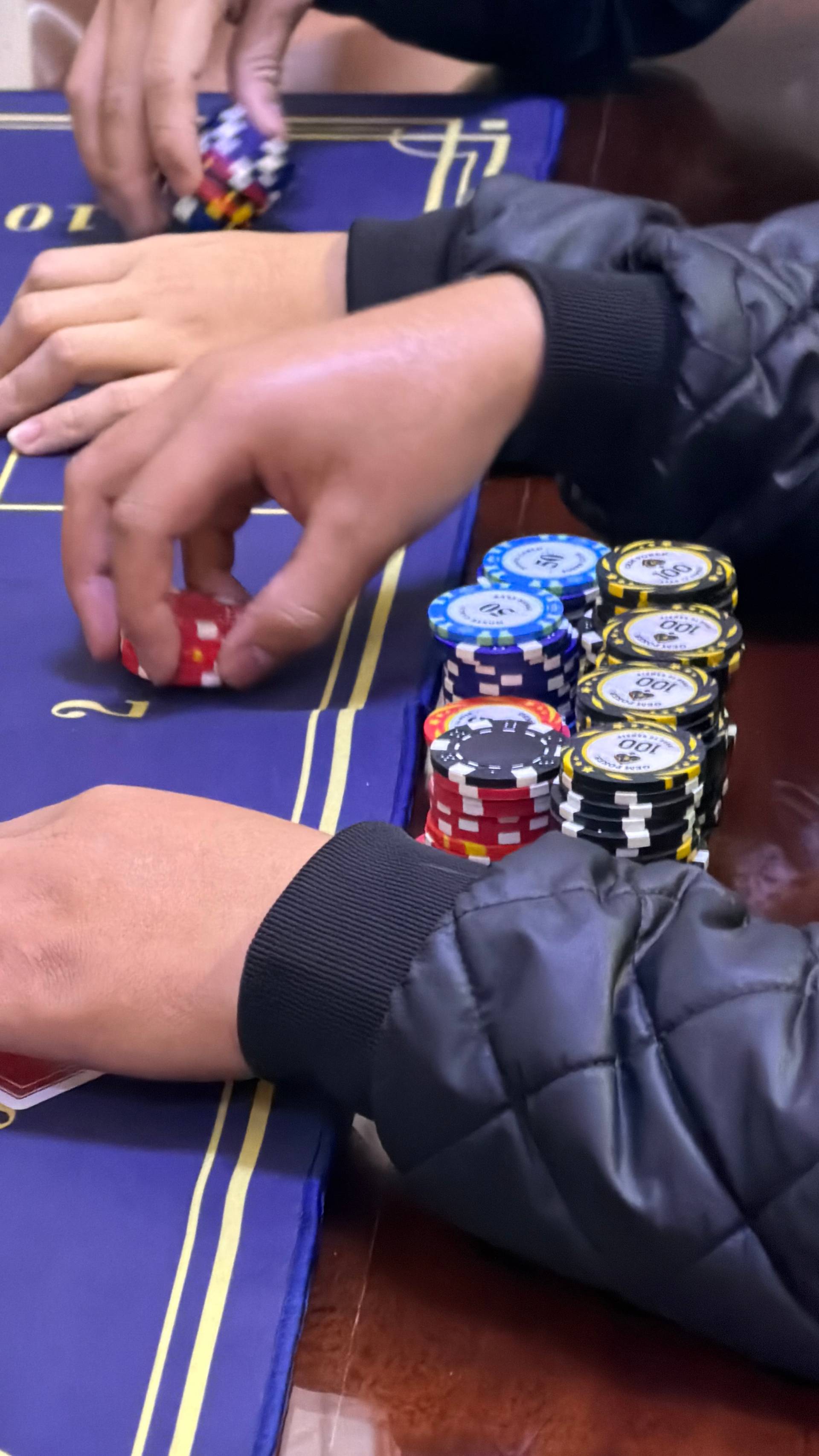 A detailed overhead shot of baccarat cards in play and colorful poker chips on the gaming table during an active hand at a Đà Lạt private card event.