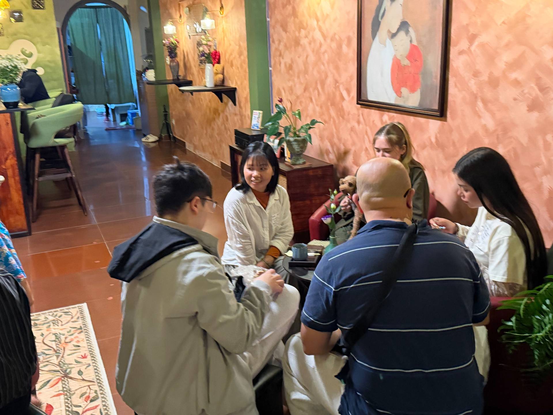 A group of friends gathered in a cozy café in Đà Lạt, Vietnam, engaging in lively conversation and enjoying each other's company over drinks.