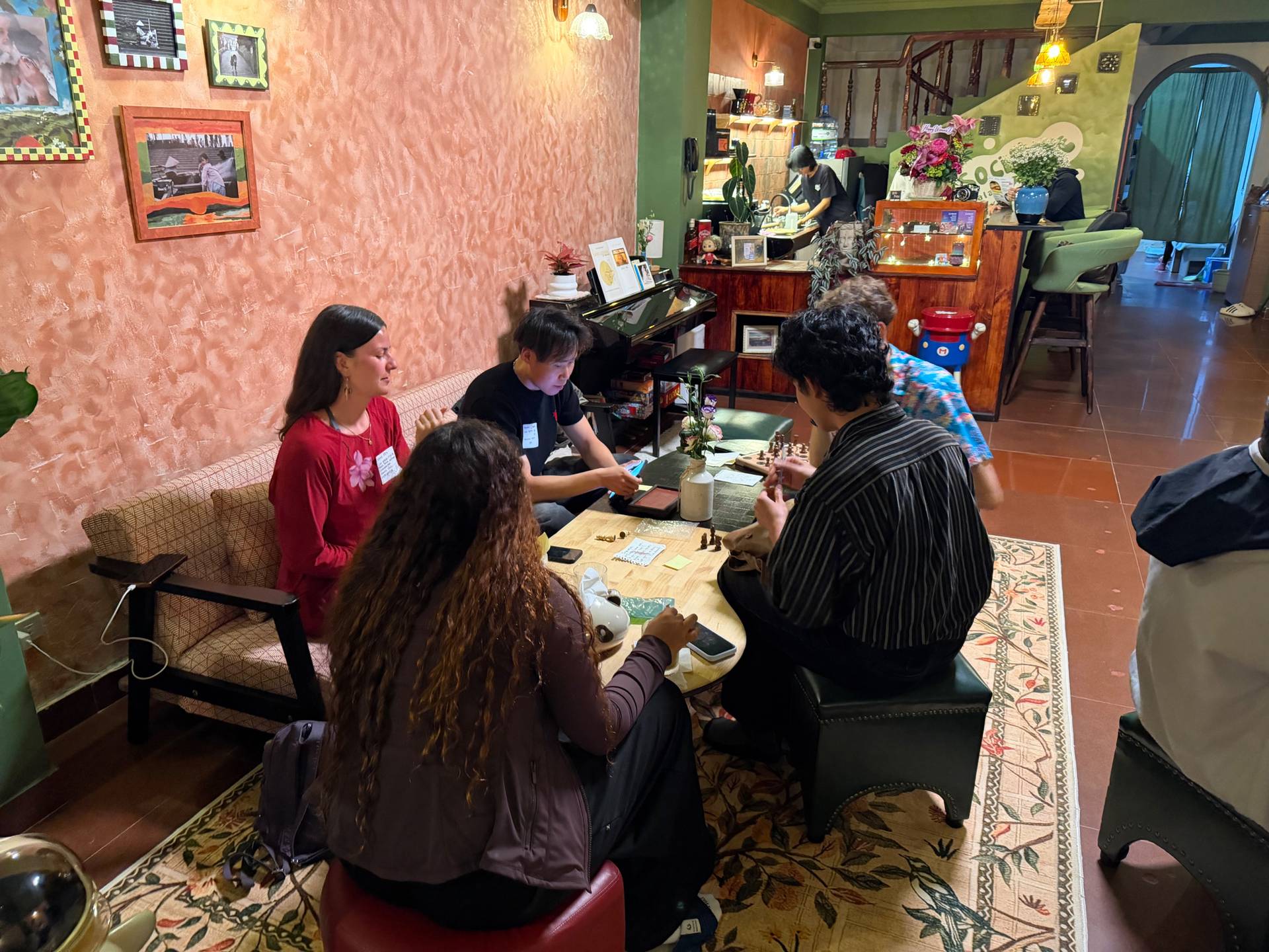 A group of friends gather in a cozy café in Đà Lạt to enjoy board games and conversation over coffee.