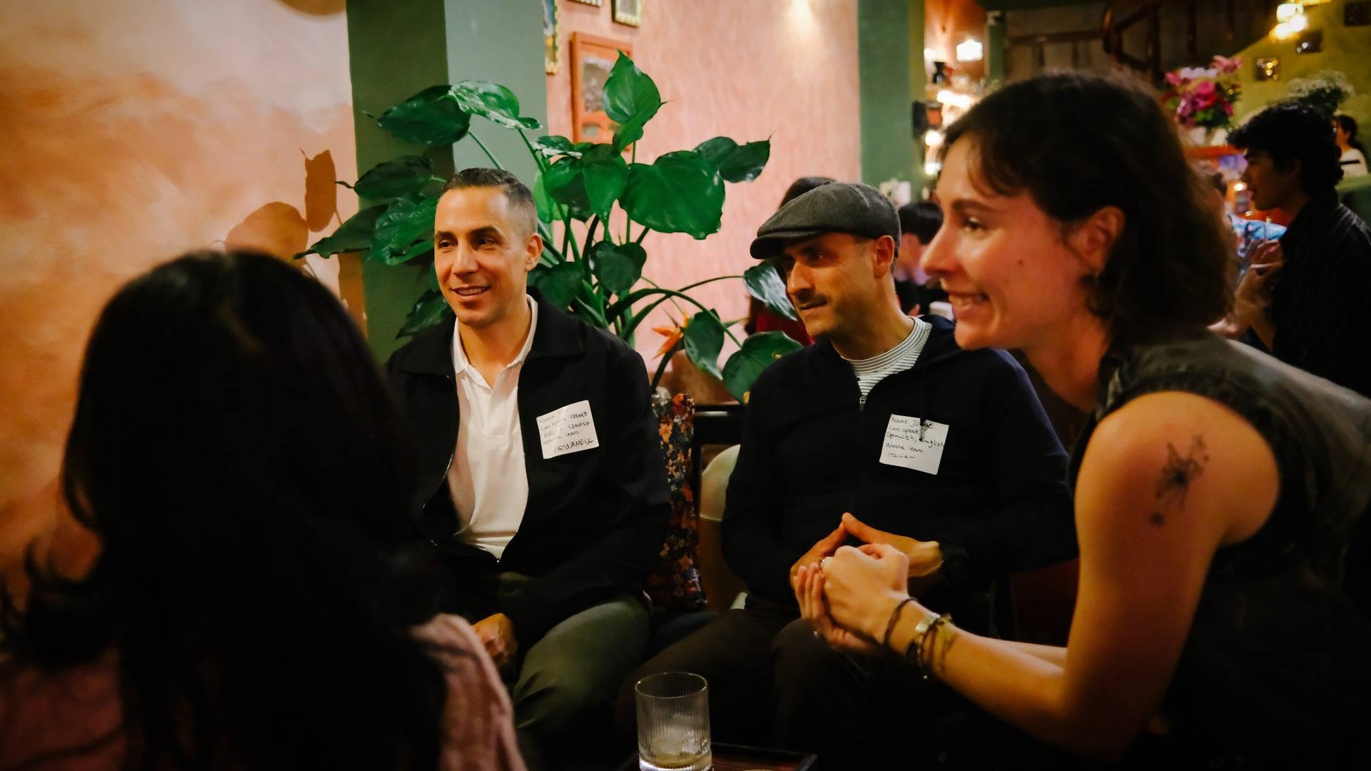 A group of friends enjoys a warm evening in Đà Lạt, Vietnam, sharing laughter and conversation over drinks at a cozy café.
