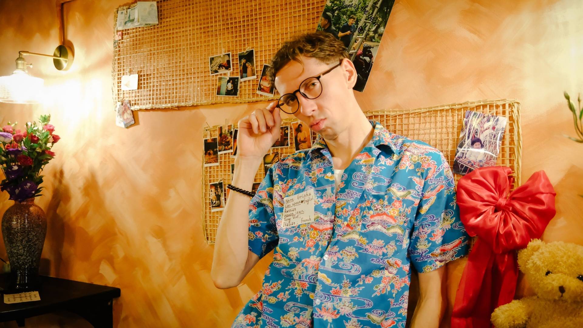 A vibrant scene in Đà Lạt featuring a person in a colorful floral shirt surrounded by personal photos and decorations, evoking a cozy and nostalgic atmosphere.