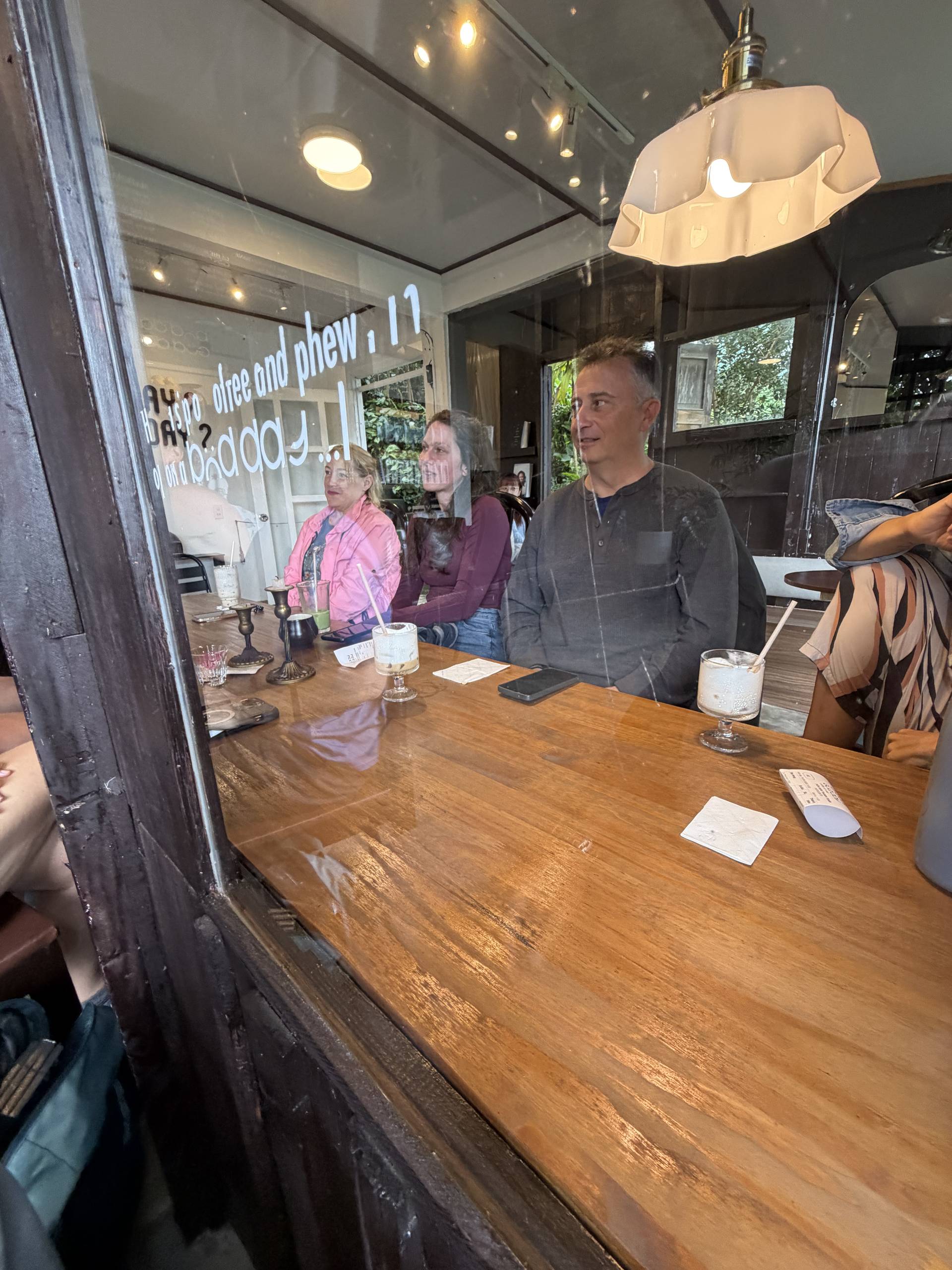 A group of friends enjoys a casual gathering in a cozy café in Đà Lạt, Vietnam, with drinks and light-hearted conversation.