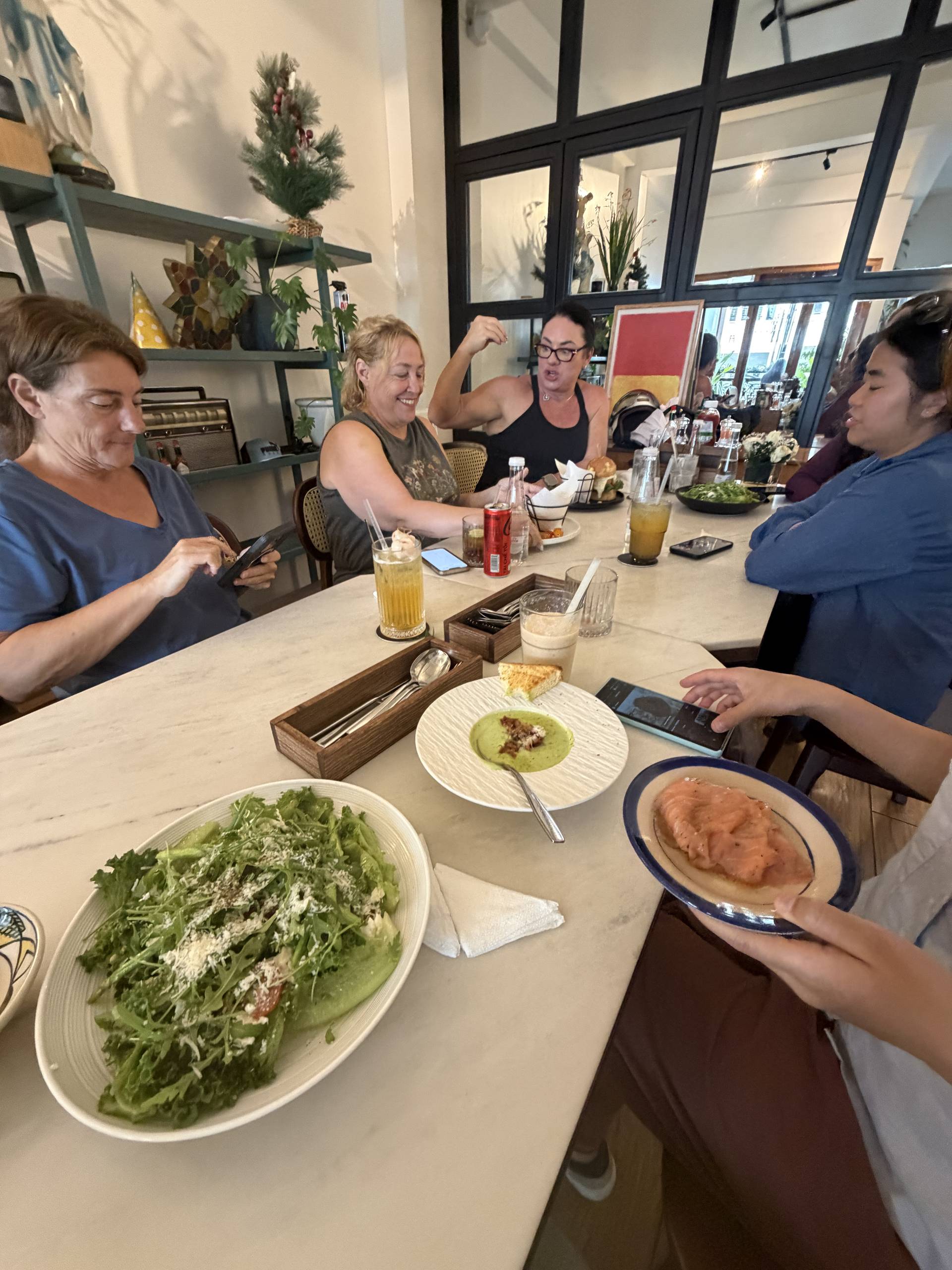 A group of friends enjoys a casual meal together in a cozy café in Đà Lạt, Vietnam, sharing laughter and good food.