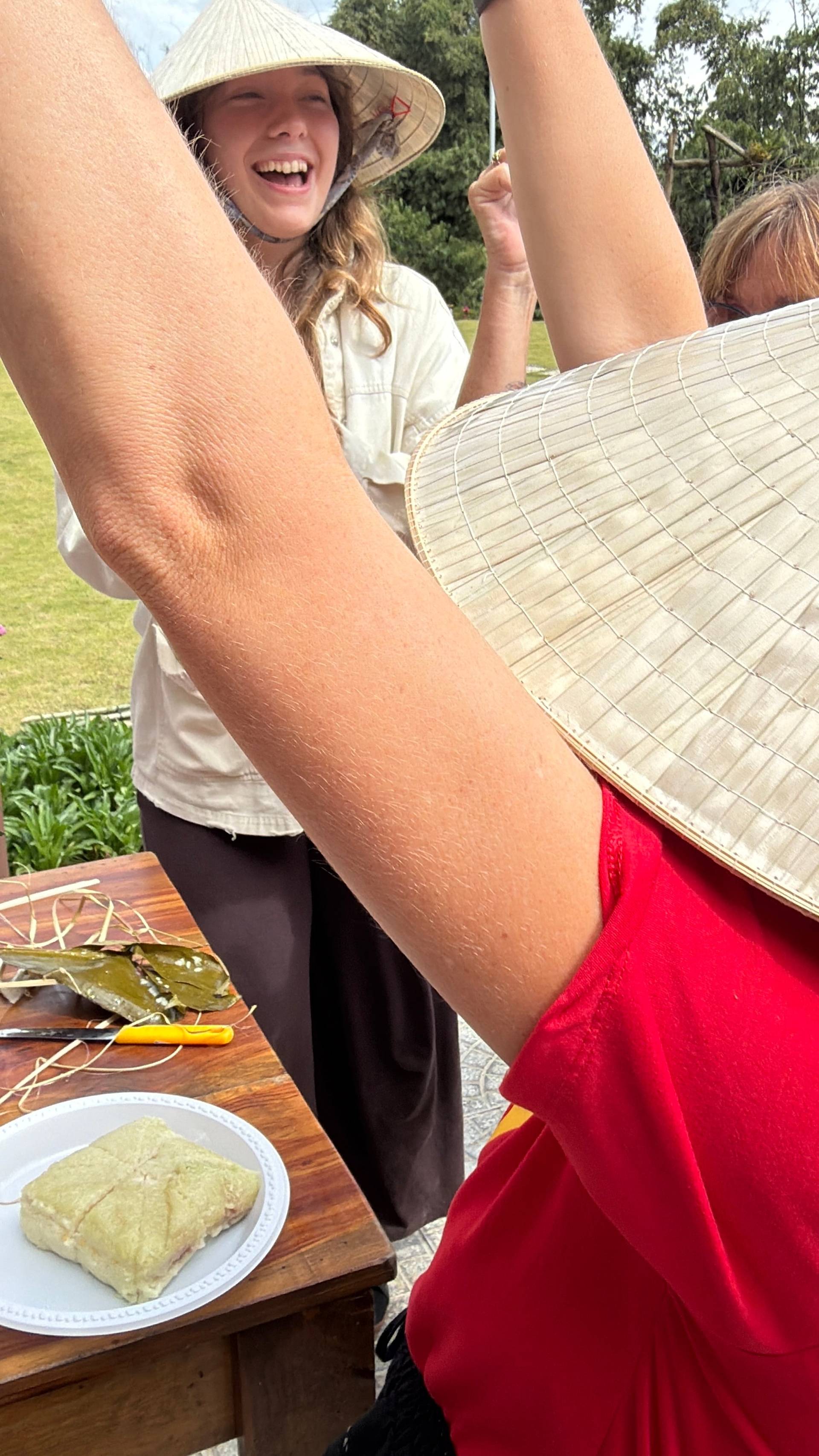 A close-up portrait of participants wearing traditional Vietnamese áo dài with vibrant red and gold star emblems and conical nón lá hats. The intimate shot captures the detailed craftsmanship and cultural pride of Vietnamese heritage dress.