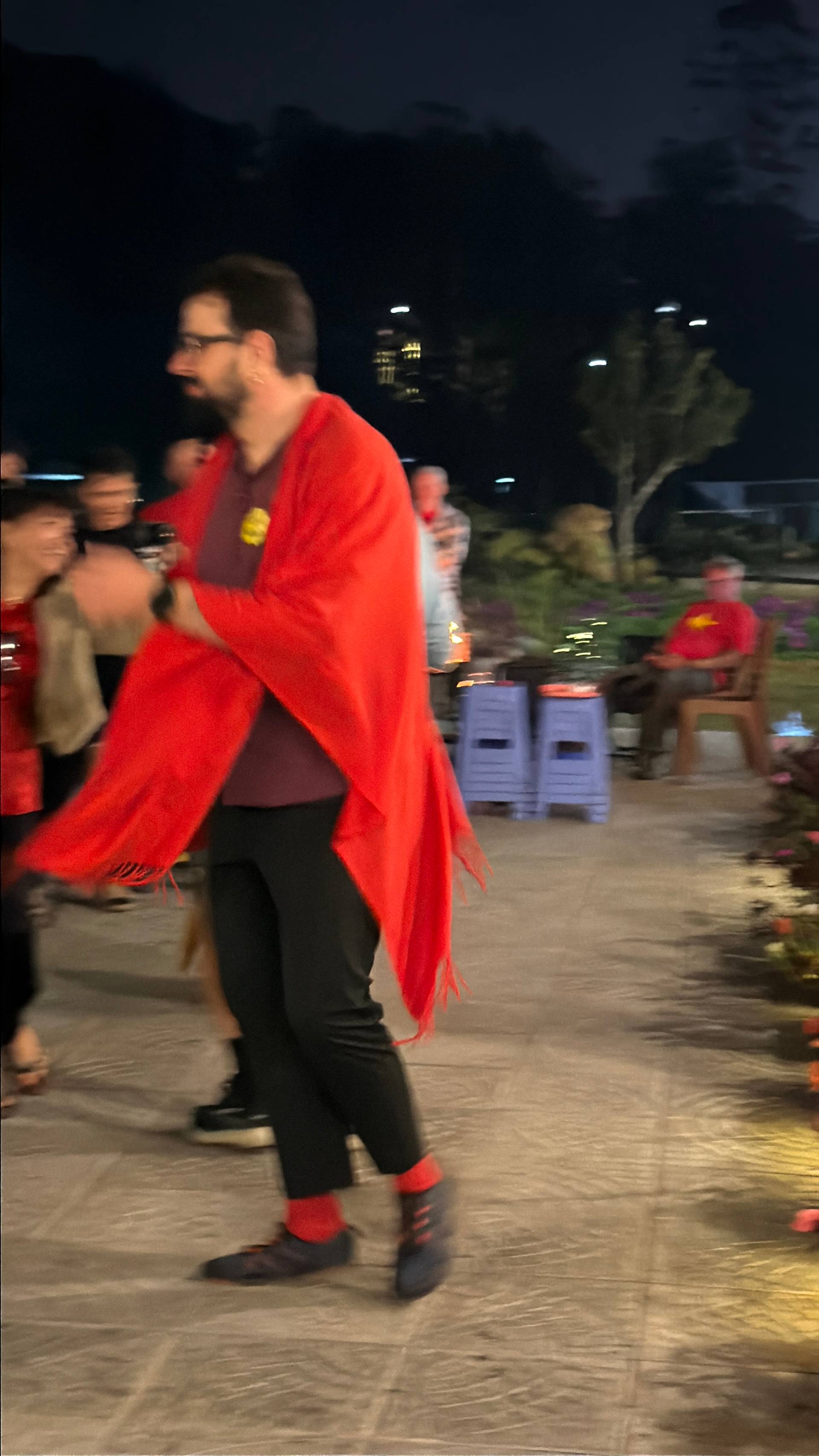 A nighttime outdoor cultural celebration in Đà Lạt featuring traditional attire and festive performance. The scene captures the vibrant spirit of Vietnamese heritage events held in mountain garden venues under evening lighting.
