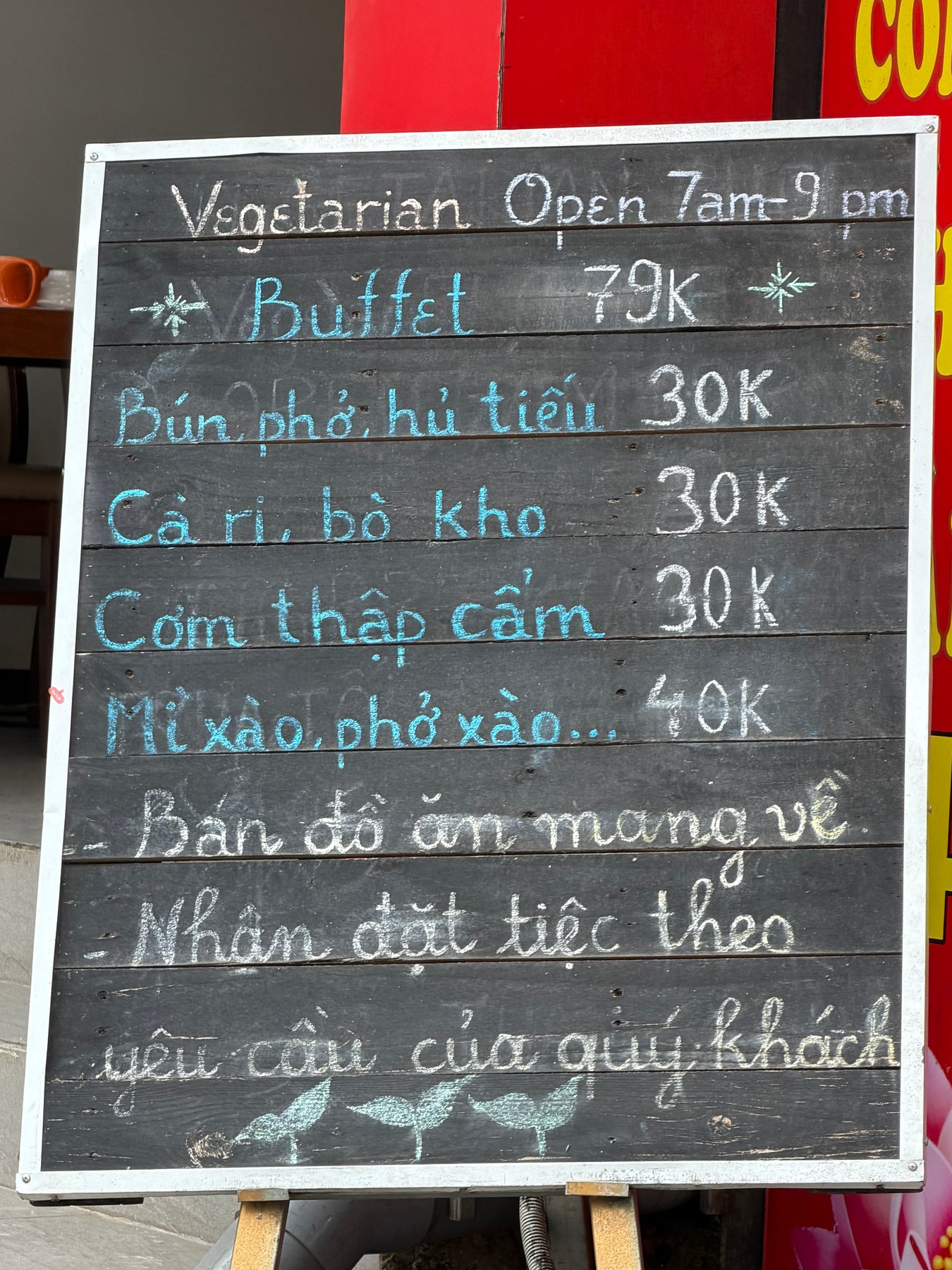 Chalkboard menu at An Lạc Tâm displaying prices for various dishes.